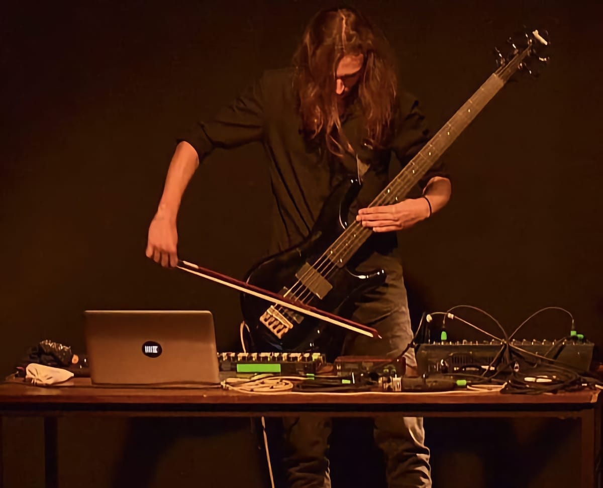 Arthur Arsenne bowing a guitar during a noise set