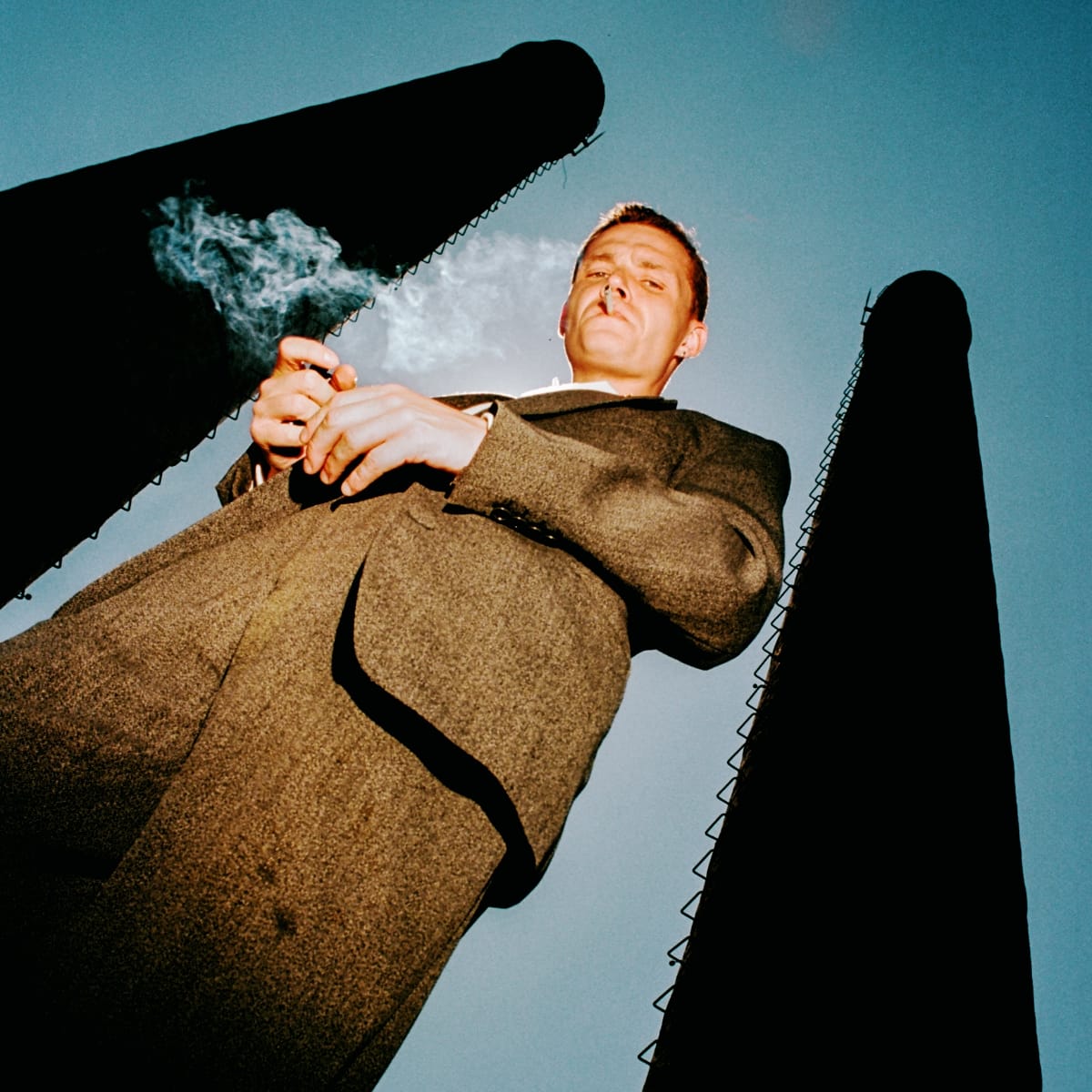 Westerman in a suit standing between two pillars. Photo by Eric Scaggiante.