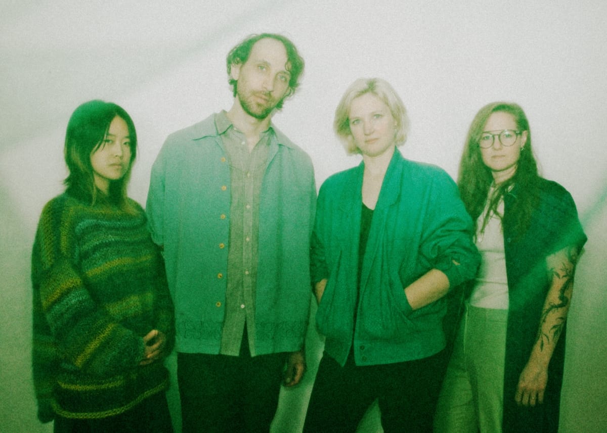 Four members of Bellbird in hazy green-tinted photograph with soft vintage aesthetic and light background. Photo by Marc Etienne Mongrain.