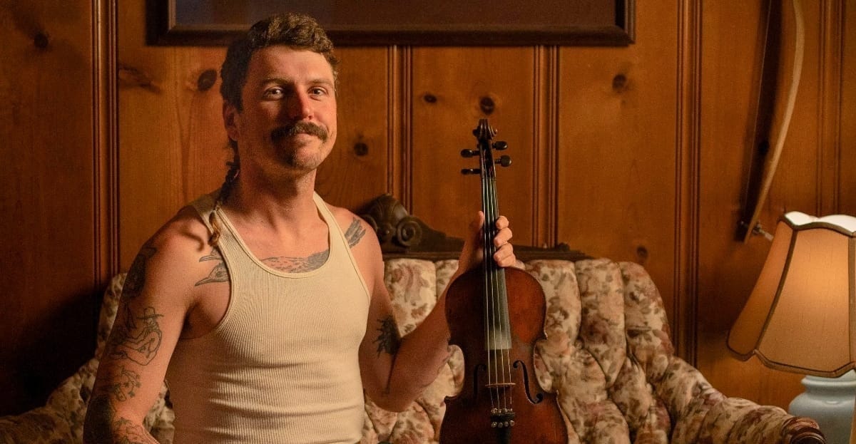 Nick Shoulders holding up a fiddle - Photo by Nick Futch