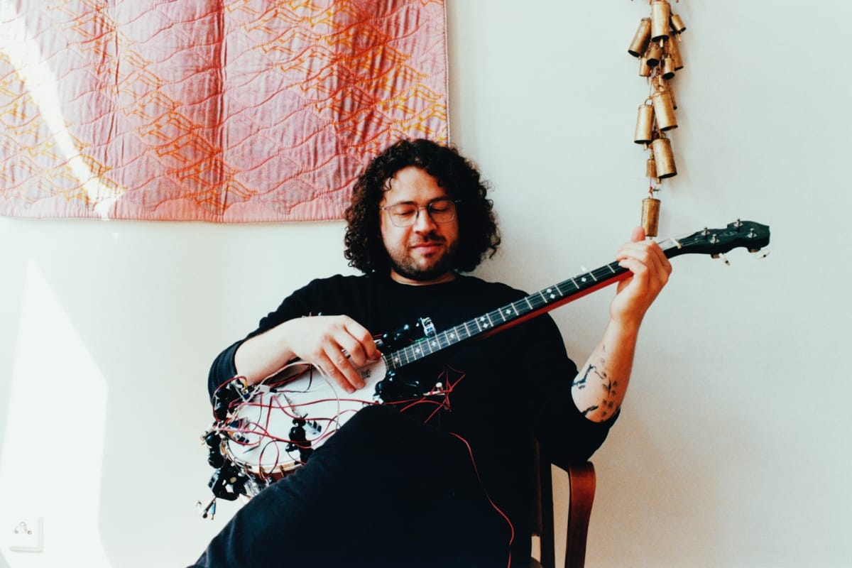 Weston Olencki playing a banjo covered in wires - Photo by Cy Klock