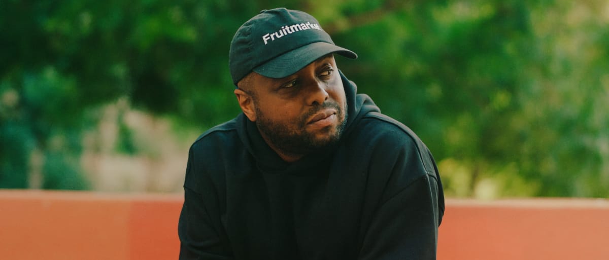 Ben Marc wearing a cap with the text 'Fruitmarket' and looking to the side - Photo by Harley Astorga