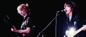 Gina and Ana of The Raincoats perform in Warsaw, 1978, vintage concert photo with guitar and microphone, purple-pink tones. Photo by Maria Helena da Silva and courtesy Ana da Silva.